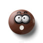 Brown donut-shaped object with cartoonish face on a white background